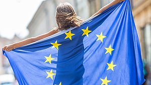 Junge Frau hält eine EU-Flagge